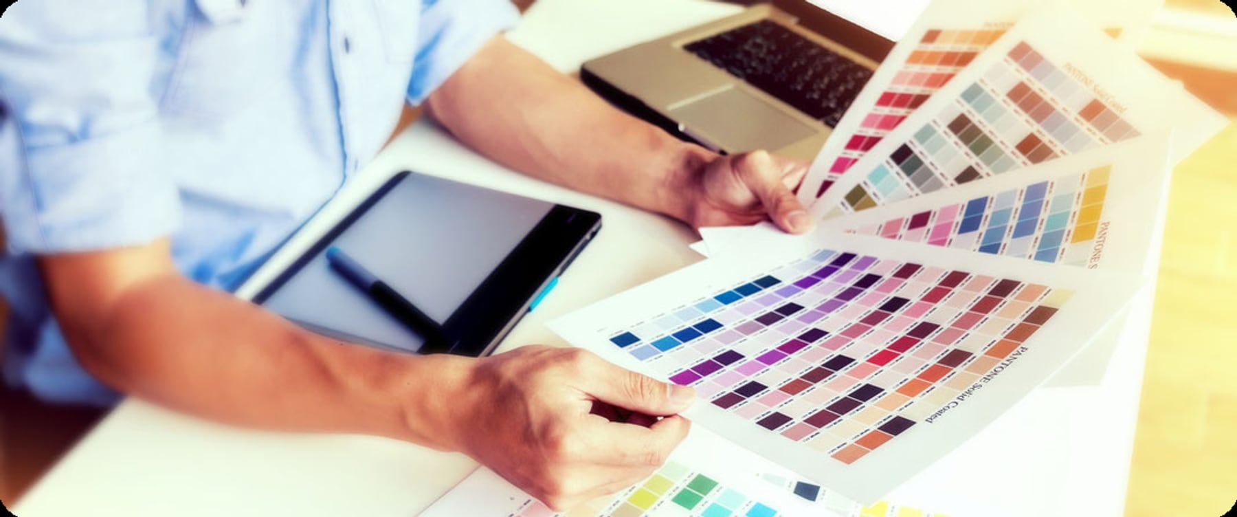 Uwe Stange bei der Farbberatung mit Pantone-Fächer und Tablet